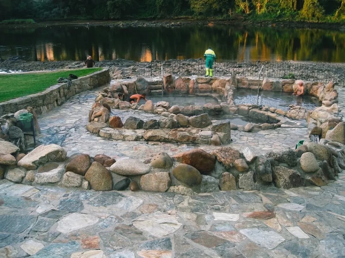 Pozas públicas de A Chavasqueira vacías, con muros de piedra en espiral junto al Miño