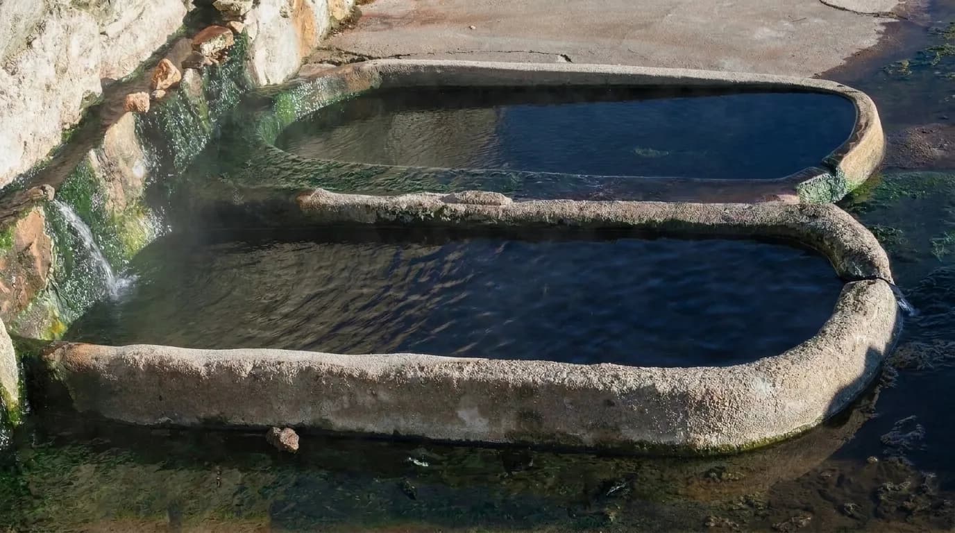 Pilas romanas de piedra de los baños de Bande con agua humeante, a la orilla del embalse